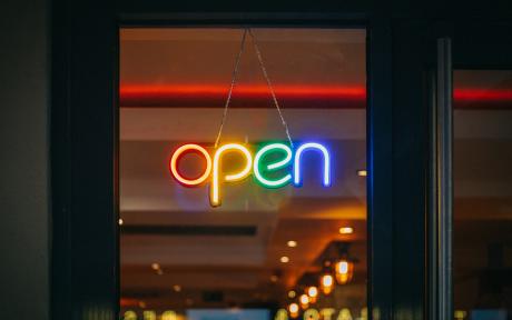 Rainbow colored neon open sign in store window - Photo by Viktor Forgacs on Unsplash