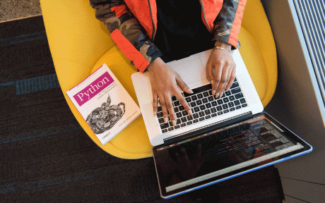 Laptop Person seated on yellow chair with laptop and O'Reilly Python book -Photo by Christina Morillo from Pexels