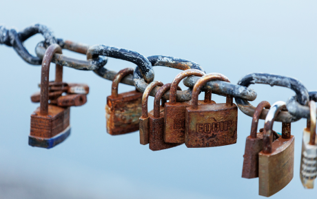 Rust padlocks on chain with blue sky background – Image by Kev from Pixabay
